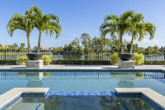 view of pool featuring an in ground hot tub and a water view