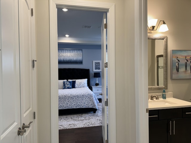 bathroom featuring crown molding, vanity, and hardwood / wood-style flooring