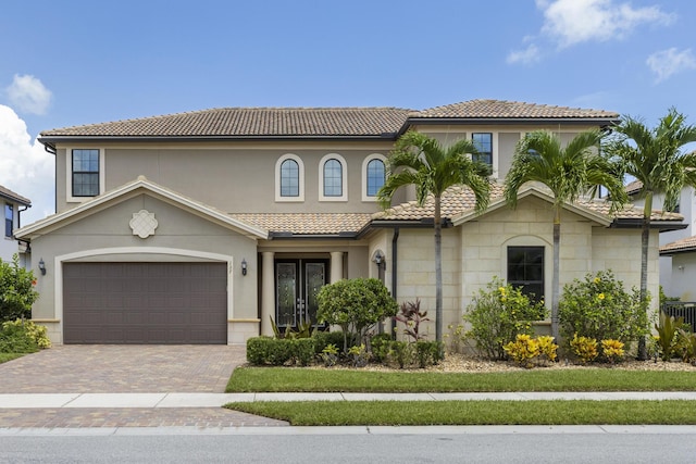 mediterranean / spanish-style home with french doors and a garage