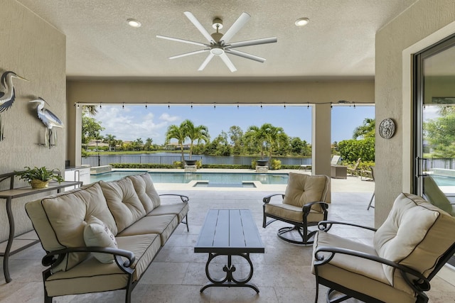 view of patio / terrace with an outdoor hangout area, a fenced in pool, ceiling fan, and a water view