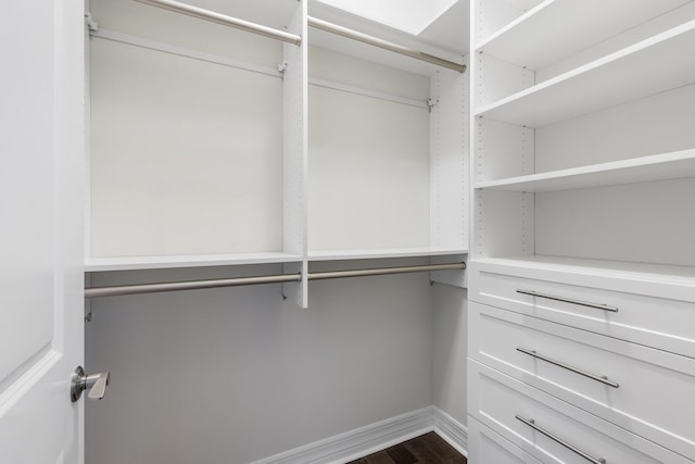 walk in closet with dark wood-type flooring