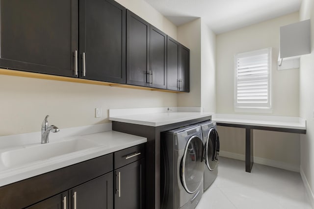 laundry area with sink, light tile patterned floors, cabinets, and independent washer and dryer