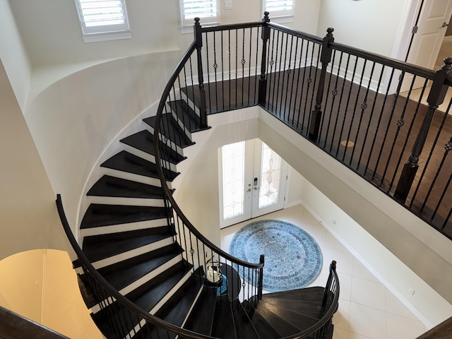 stairs featuring tile patterned flooring and french doors