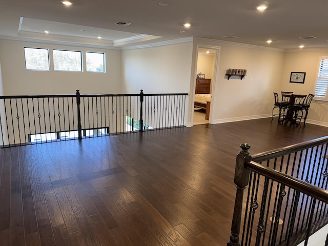 interior space with a tray ceiling, dark hardwood / wood-style floors, and crown molding