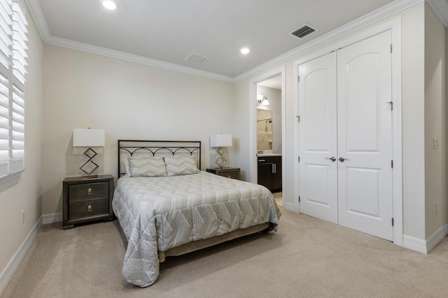 carpeted bedroom featuring ensuite bathroom, a closet, and ornamental molding