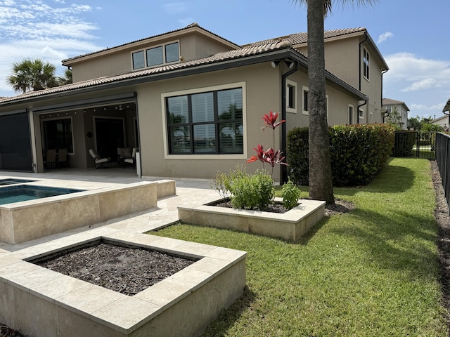 back of house with a lawn and a patio