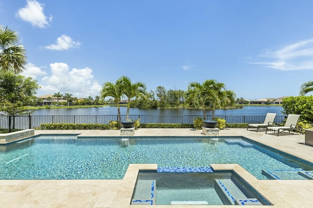 view of swimming pool with a patio area, a water view, and an in ground hot tub