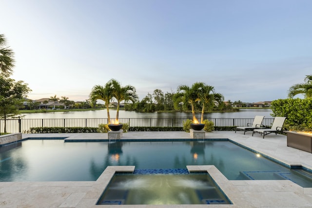 view of swimming pool with an in ground hot tub, a water view, and a patio area