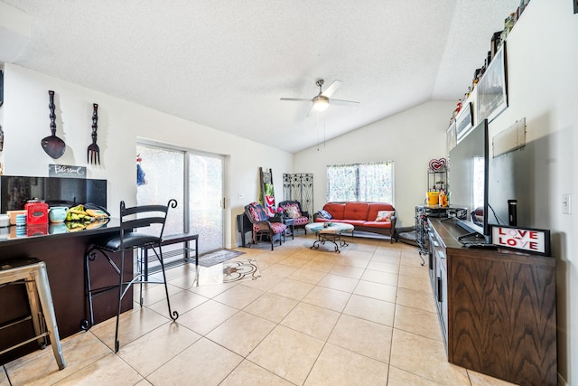 tiled living room featuring ceiling fan, a textured ceiling, and lofted ceiling