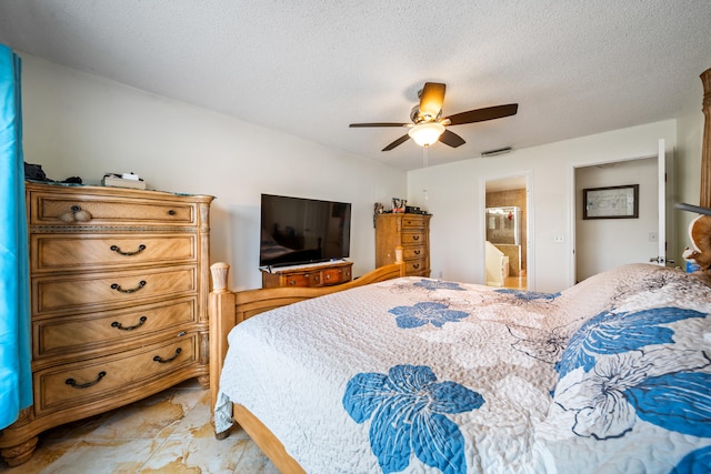 bedroom featuring a textured ceiling, ceiling fan, connected bathroom, and light tile patterned floors