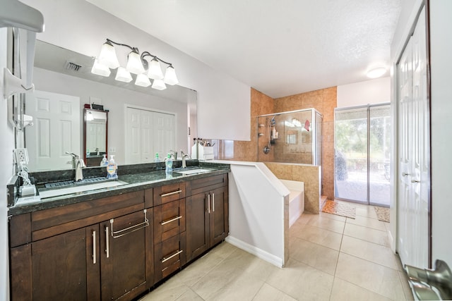 bathroom featuring plus walk in shower, a textured ceiling, vanity, and tile patterned floors