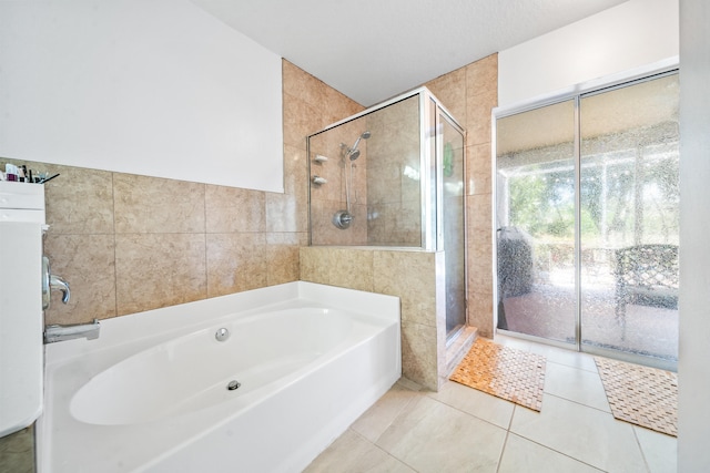 bathroom featuring independent shower and bath, tile patterned flooring, and tile walls