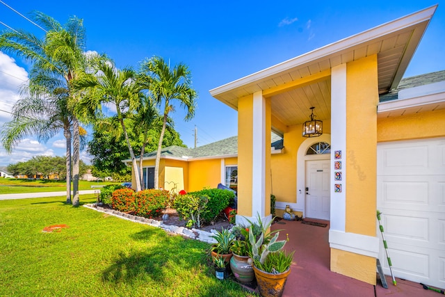 entrance to property featuring a lawn and a garage