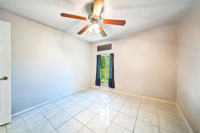 tiled empty room with ceiling fan and a textured ceiling