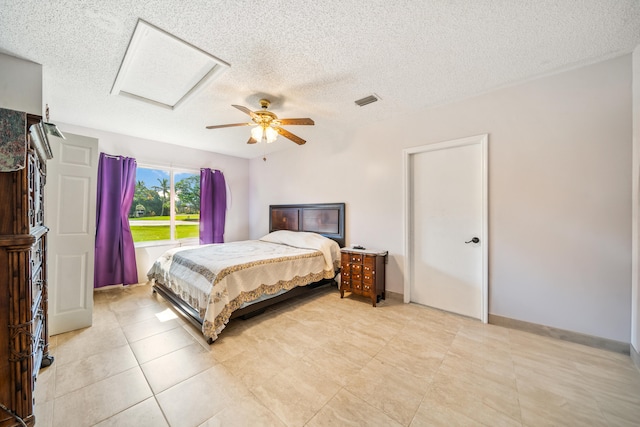 tiled bedroom featuring a textured ceiling and ceiling fan