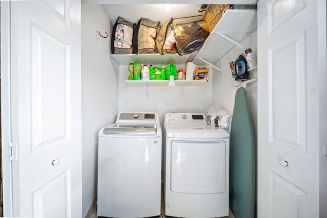 clothes washing area with washer and dryer and a textured ceiling