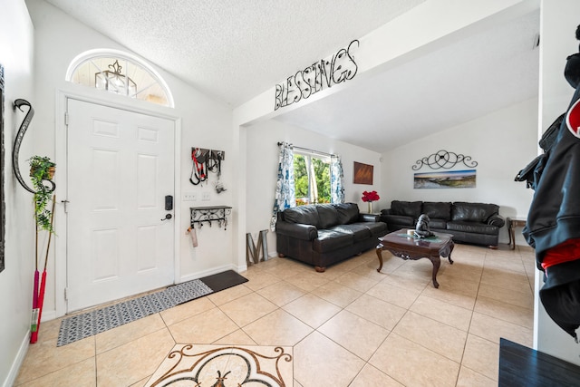 tiled entryway with a textured ceiling and vaulted ceiling