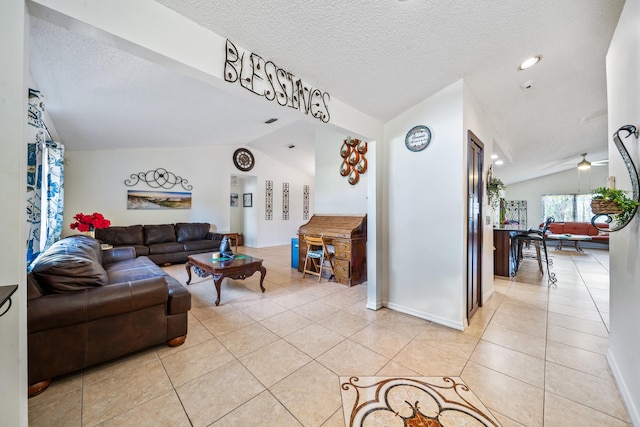 tiled living room featuring ceiling fan, a textured ceiling, and lofted ceiling