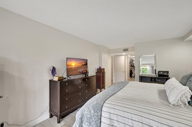 bedroom featuring a textured ceiling and light hardwood / wood-style floors