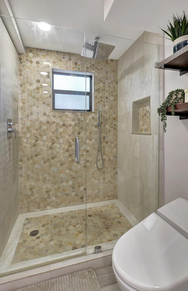 bathroom featuring walk in shower and toilet