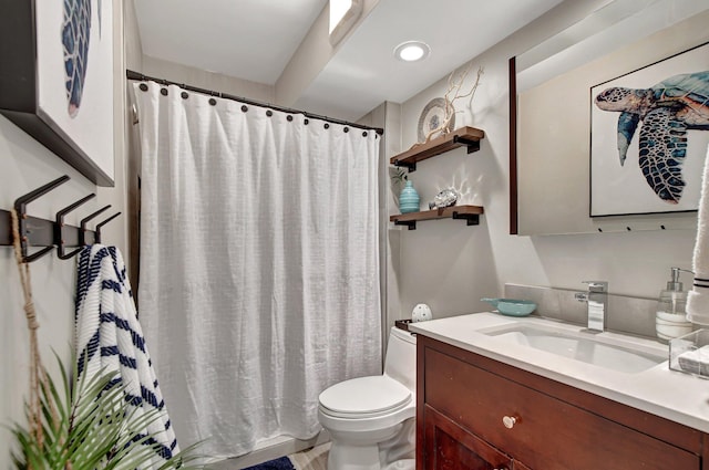 bathroom featuring walk in shower, vanity, and toilet