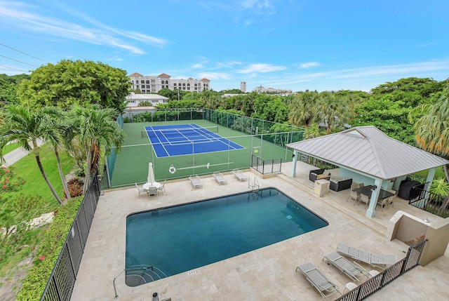 view of pool with a patio area and tennis court