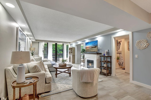 living room featuring a textured ceiling and floor to ceiling windows