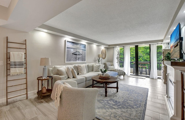 living room featuring expansive windows, a textured ceiling, and light wood-type flooring