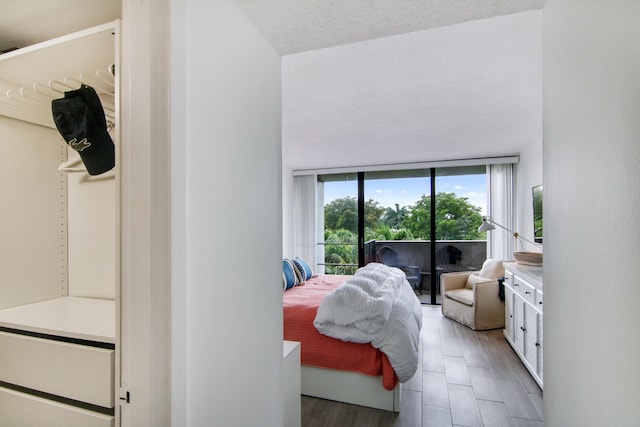 bedroom with hardwood / wood-style flooring, access to exterior, and a textured ceiling