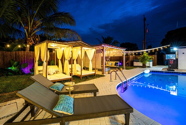 pool at night with a patio area