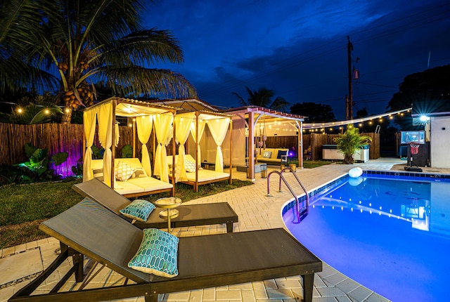 pool at twilight with an outdoor hangout area and a patio