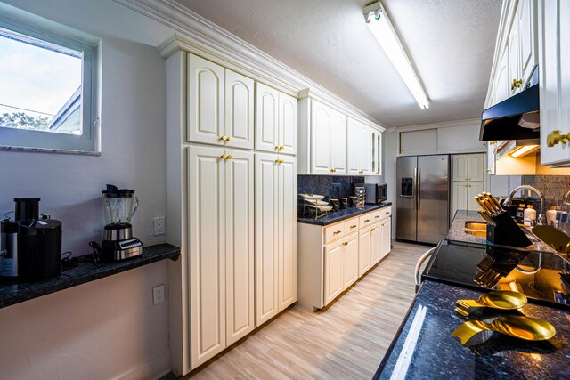 kitchen featuring light hardwood / wood-style flooring, backsplash, stainless steel refrigerator with ice dispenser, wall chimney exhaust hood, and white cabinets