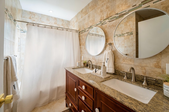 bathroom featuring plenty of natural light, double sink vanity, tile patterned floors, and tile walls