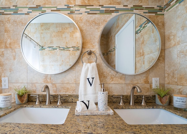 bathroom featuring tile walls, decorative backsplash, and double vanity