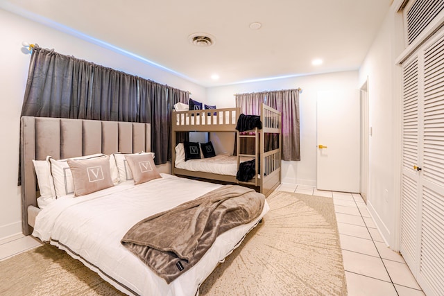 bedroom with light tile patterned floors and a closet