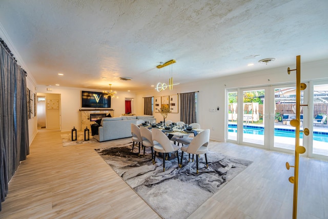 dining space featuring french doors, ornamental molding, and a textured ceiling