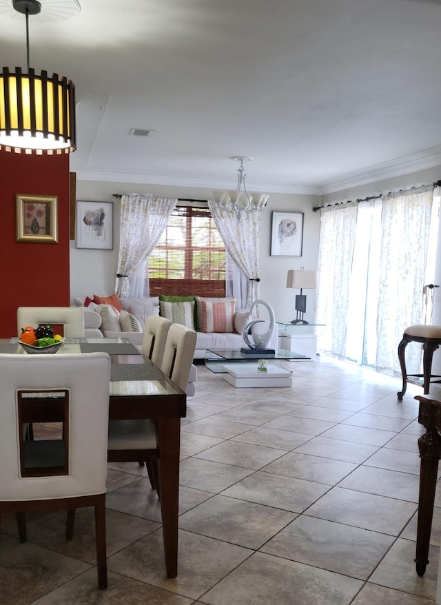 dining area featuring light tile patterned floors, an inviting chandelier, and crown molding