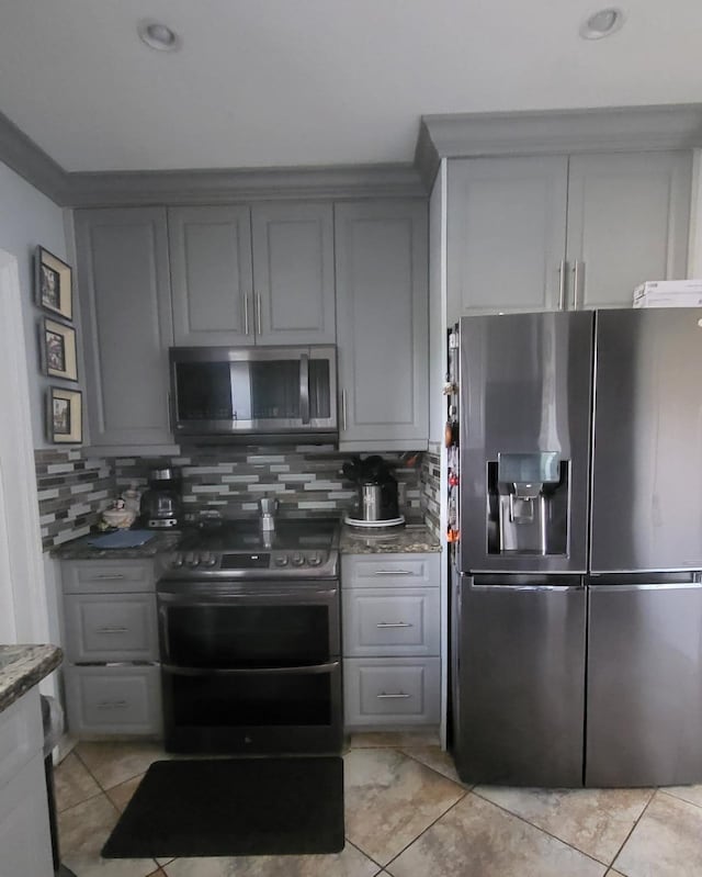 kitchen featuring backsplash, gray cabinets, stainless steel appliances, and light tile patterned flooring