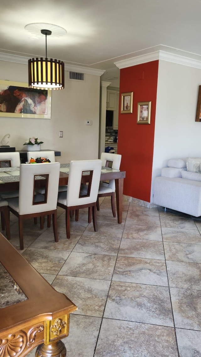 tiled dining space featuring crown molding