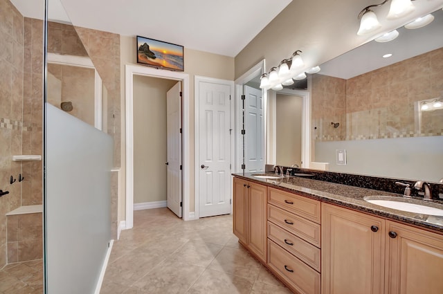 bathroom featuring vanity, tile patterned flooring, and a tile shower