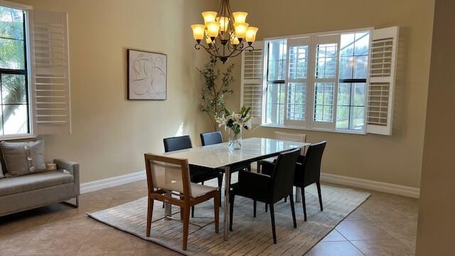 dining area featuring light tile patterned flooring and an inviting chandelier