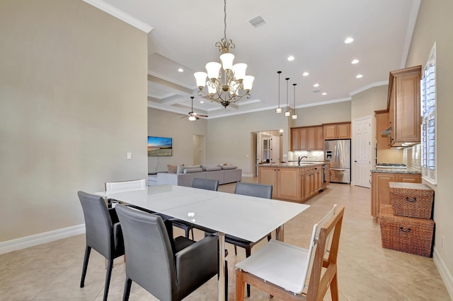 dining space with ceiling fan with notable chandelier, sink, ornamental molding, coffered ceiling, and light tile patterned floors