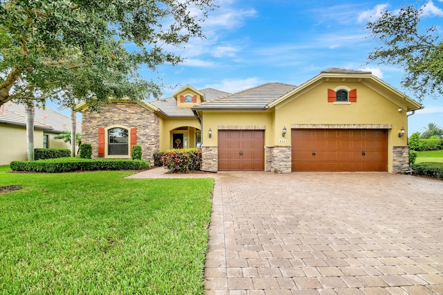 view of front of home with a garage and a front lawn