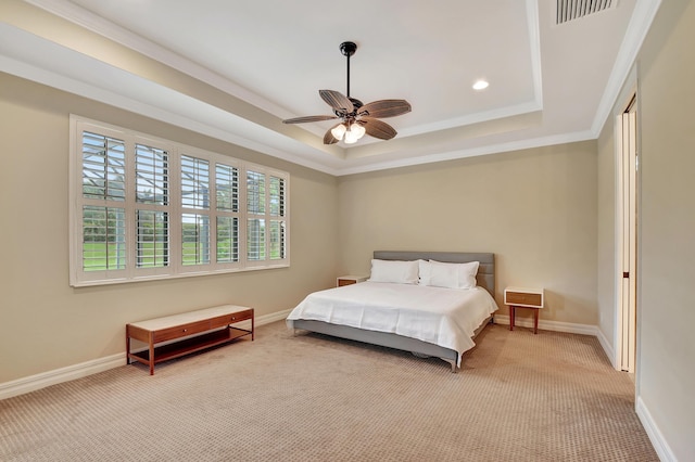 bedroom with ornamental molding, light carpet, ceiling fan, and a tray ceiling