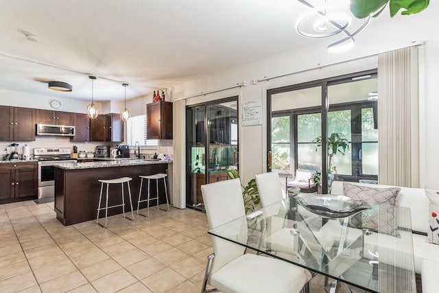 dining space featuring light tile patterned floors and sink