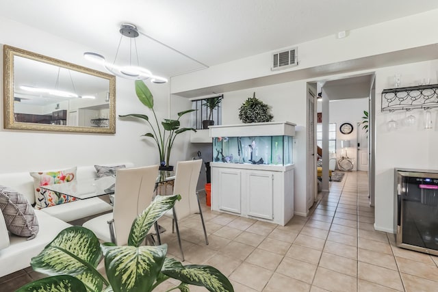 kitchen featuring white cabinetry, light tile patterned floors, wine cooler, and hanging light fixtures