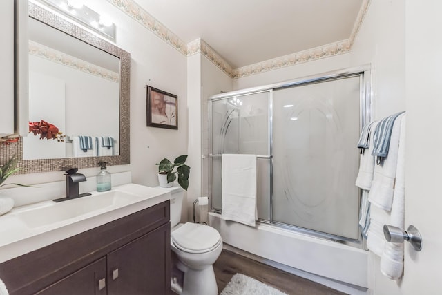 full bathroom with vanity, ornamental molding, shower / bath combination with glass door, and toilet