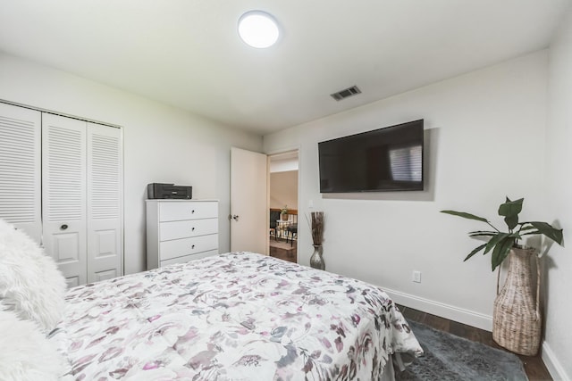 bedroom with dark hardwood / wood-style floors and a closet