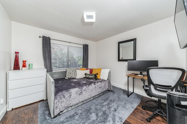 bedroom with dark hardwood / wood-style floors and a textured ceiling