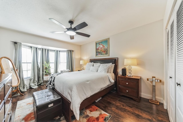 bedroom with a closet, a textured ceiling, dark hardwood / wood-style floors, and ceiling fan